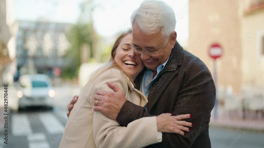 Middle age couple couple smiling confident hugging each other at street Middle age couple couple smiling confident hugging each other at street