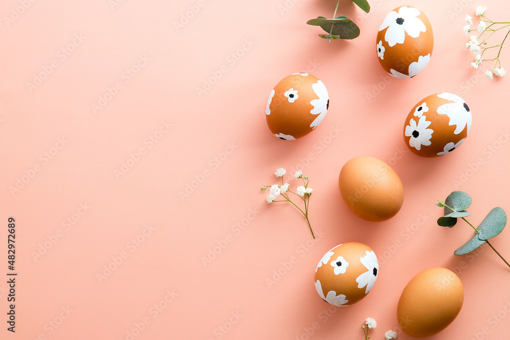 Elegant Easter flat lay composition. Colorful Easter eggs and flowers on pastel pink table. Happy Easter concept. Minimal style.