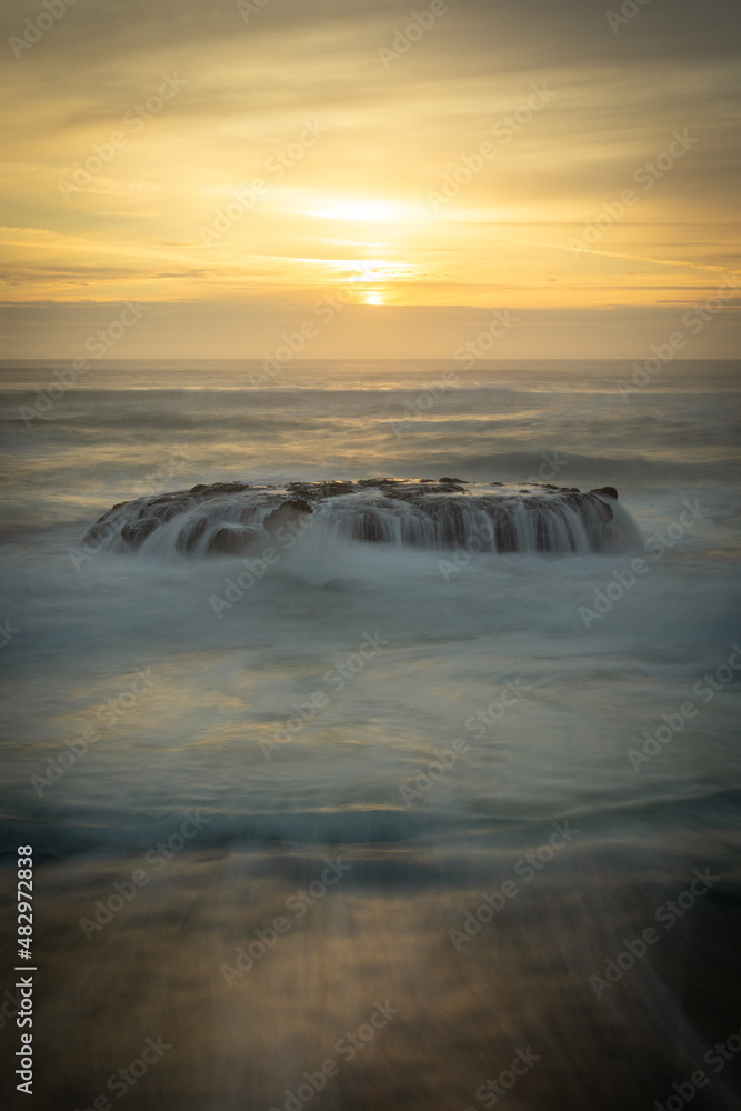 Obraz premium ocean sunset waves on rocks