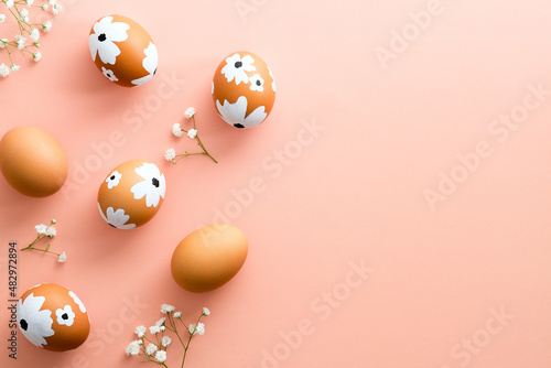 Fotografie Painted Easter eggs and gypsophila flowers on pastel pink background
