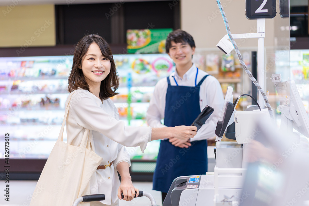 Obraz premium 電子マネー決済をおすすめする店員とお客様