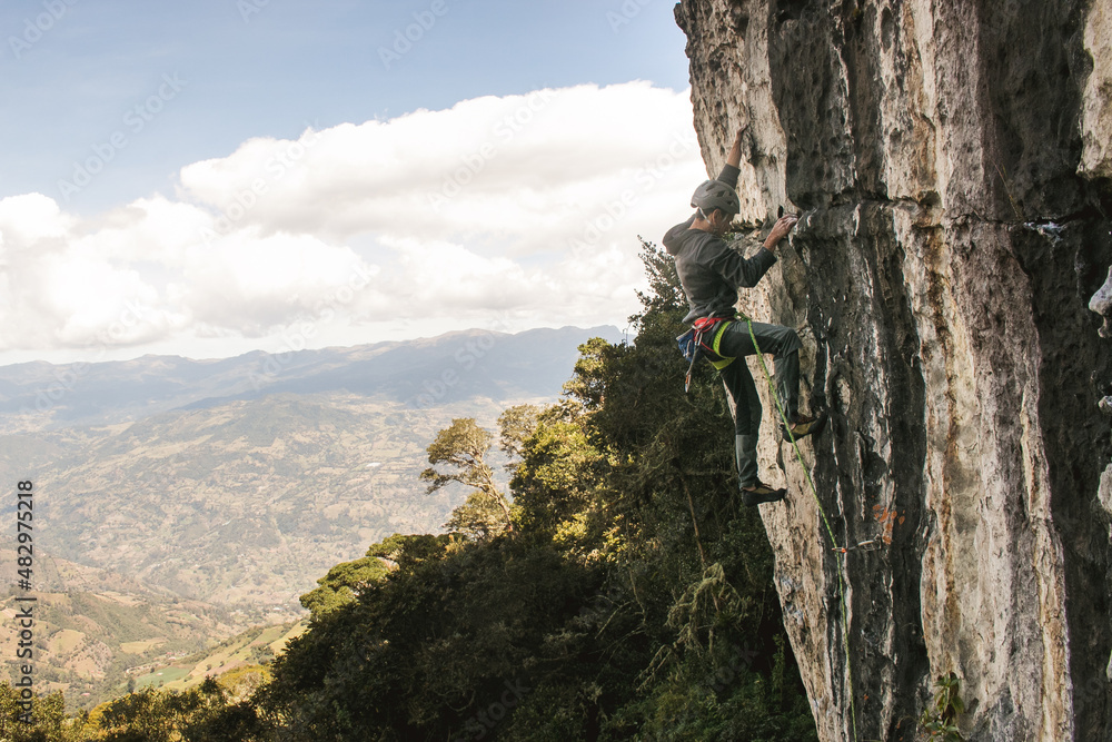 Candid landscape of fit dark skinned male rock climber and mountains Candid landscape of fit dark skinned male rock climber and mountains