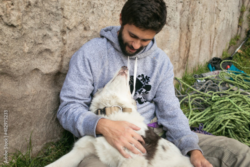 Hispanic man and brown border collie love each other outdoors