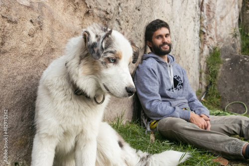 Hispanic man and brown border collie love each other outdoors