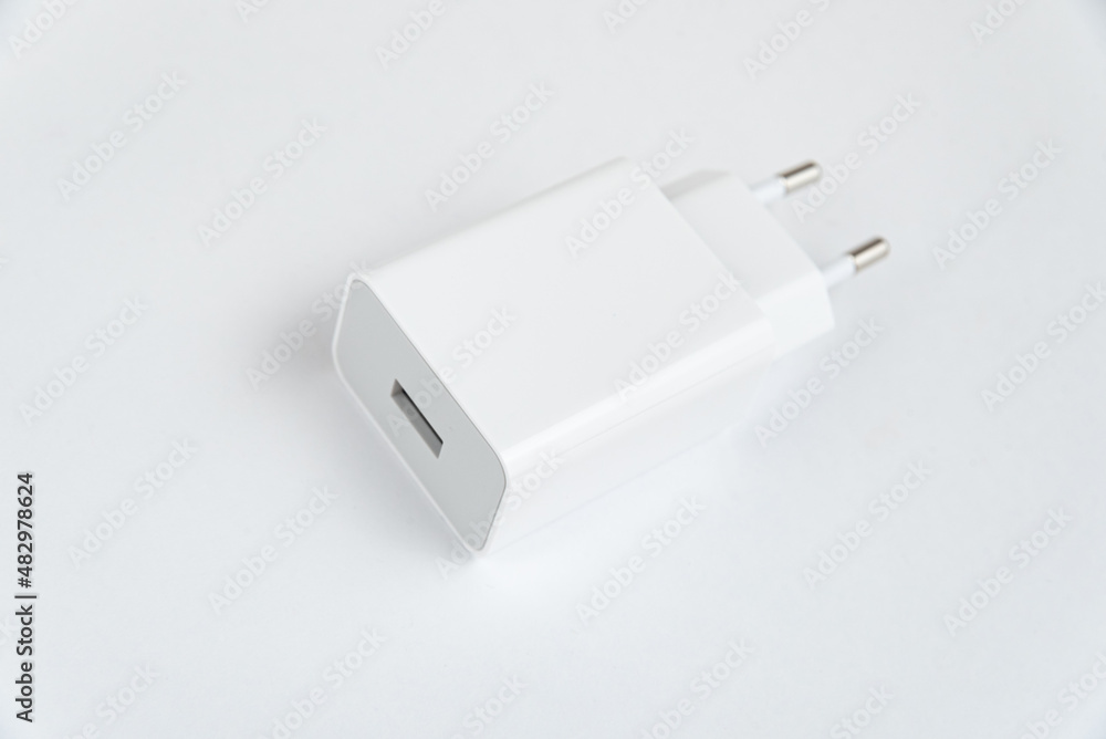 White cell phone charger on the white isolated background White cell phone charger on the white isolated background