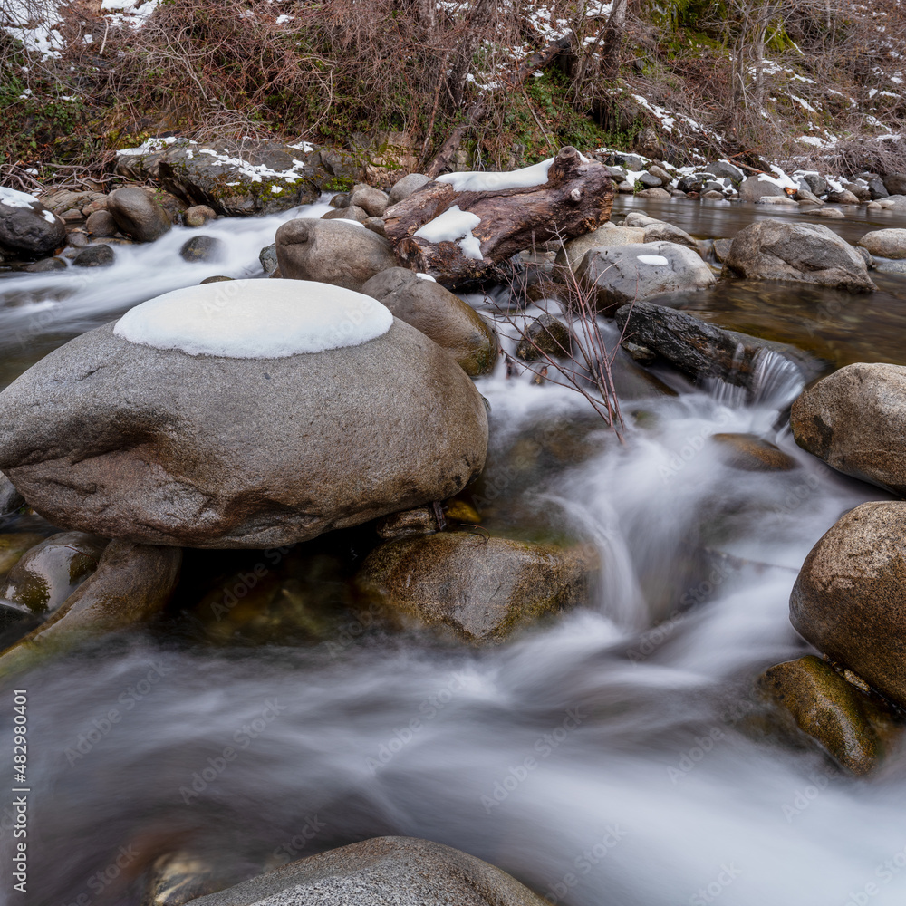 A scenic landscape of a mountain creek covered in snow in the Sierra Nevada Mountains of Northern California. A scenic landscape of a mountain creek covered in snow in the Sierra Nevada Mountains of Northern California.