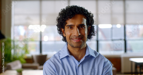 Happy young professional businessman looking at camera. Content smiling extremely happy, handsome smart young adult entrepreneur leader in office