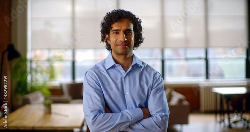 Happy young professional businessman looking at camera. Content smiling extremely happy, handsome smart young adult entrepreneur leader in office