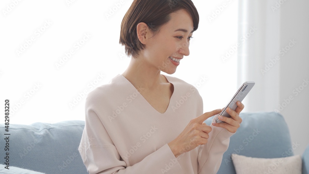 笑顔で携帯を触る日本人女性 笑顔で携帯を触る日本人女性