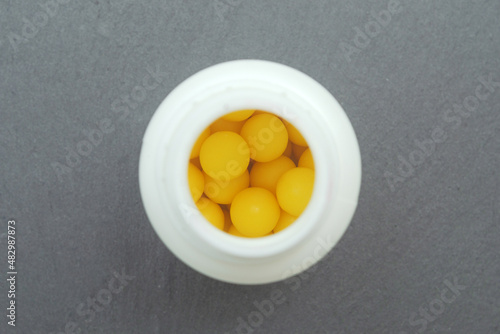 round vitamin c tablets in a jar top view