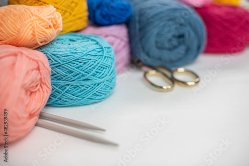 A lot of colorful wool balls of knitted yarn on a white background. The concept of handmade work, needlework and the sale of thread. Balls of alpaca wool, made by hand and colored with plant extract.