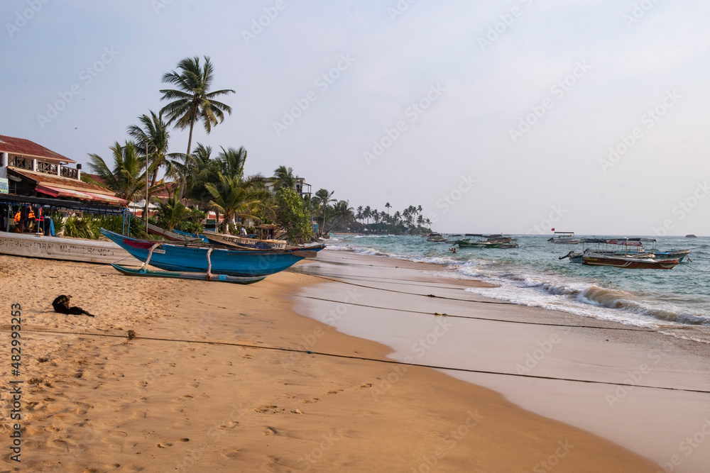 Boat on the sand beach with palms and ocean waves. Boat on the sand beach with palms and ocean waves.