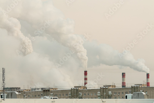 industrial chimneys with heavy white smoke causing air pollution problem