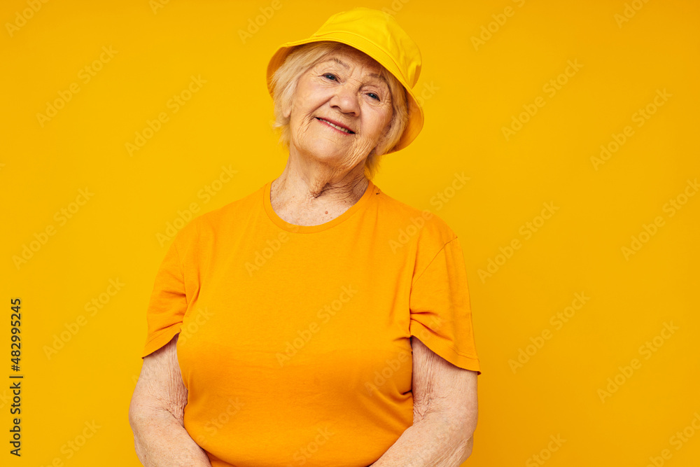 smiling elderly woman in casual t-shirt yellow panama yellow background smiling elderly woman in casual t-shirt yellow panama yellow background