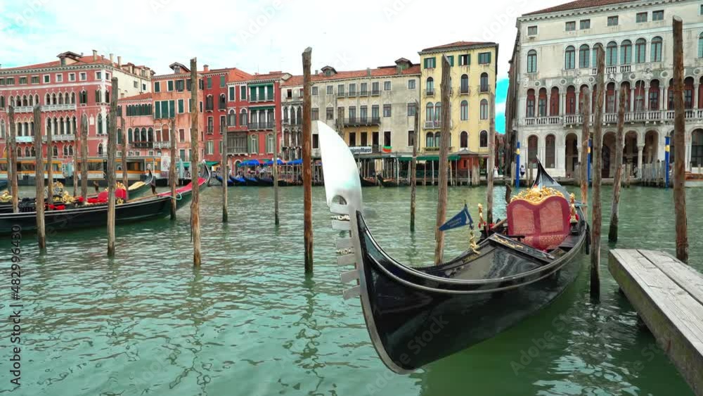 Close up of gondola traditional boat moored on gran canal river in Venice city center with urban skyline on background Close up of gondola traditional boat moored on gran canal river in Venice city center with urban skyline on background