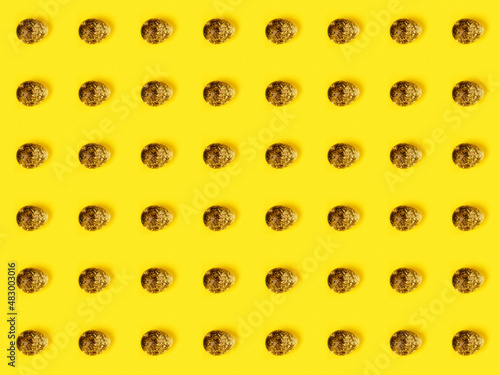 The easter background with the quail brown eggs pattern on the trendy yellow background.