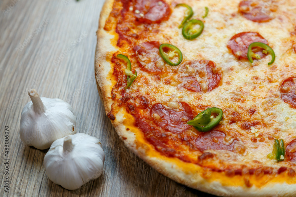 pizza with salami, mozarella, green hot pepper