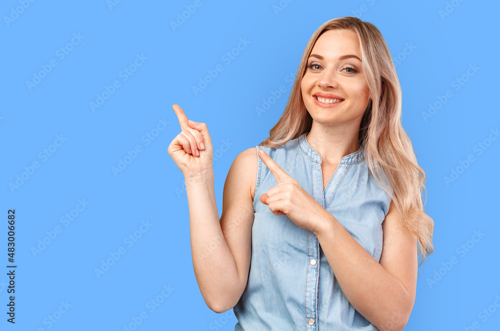 Young smiling woman pointing to copy space isolated on color background Young smiling woman pointing to copy space isolated on color background