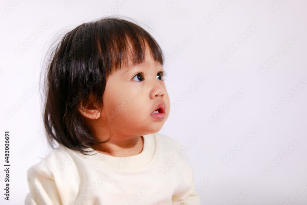 Studio shot of little cute short black hair Asian baby girl daughter model in casual plaid skirt sitting and smiling on white background Studio shot of little cute short black hair Asian baby girl daughter model in casual plaid skirt sitting and smiling on white background