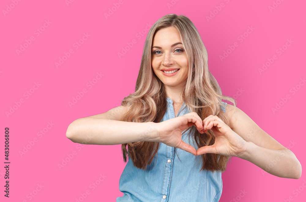 Young woman showing hand heart gesture isolated on color background Young woman showing hand heart gesture isolated on color background