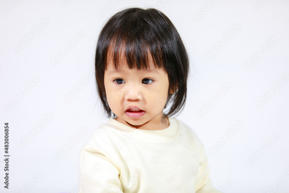 Studio shot of little cute short black hair Asian baby girl daughter model in casual plaid skirt sitting and smiling on white background Studio shot of little cute short black hair Asian baby girl daughter model in casual plaid skirt sitting and smiling on white background