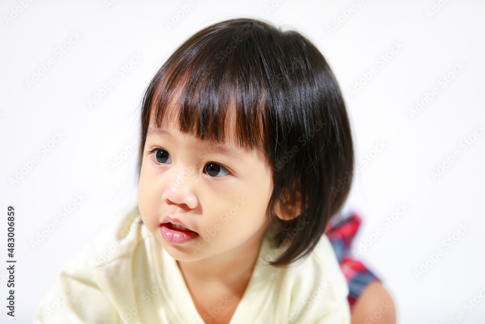 Studio shot of little cute short black hair Asian baby girl daughter model in casual plaid skirt sitting on floor smiling laughing on white background Studio shot of little cute short black hair Asian baby girl daughter model in casual plaid skirt sitting on floor smiling laughing on white background