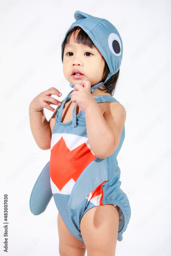 Studio shot of little beautiful kindergarten Asian baby girl daughter model in cute gray shark costume swimsuit outfit standing on white background Studio shot of little beautiful kindergarten Asian baby girl daughter model in cute gray shark costume swimsuit outfit standing on white background