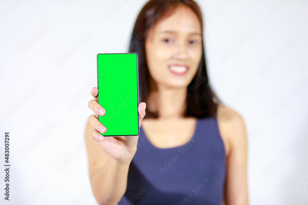 Isolated studio cutout shot of Asian young female teenager model in crop top shirt and jeans holding smartphone on white background Isolated studio cutout shot of Asian young female teenager model in crop top shirt and jeans holding smartphone on white background