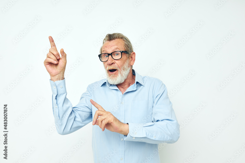 Senior grey-haired man lifestyle posing hand gesture light background Senior grey-haired man lifestyle posing hand gesture light background
