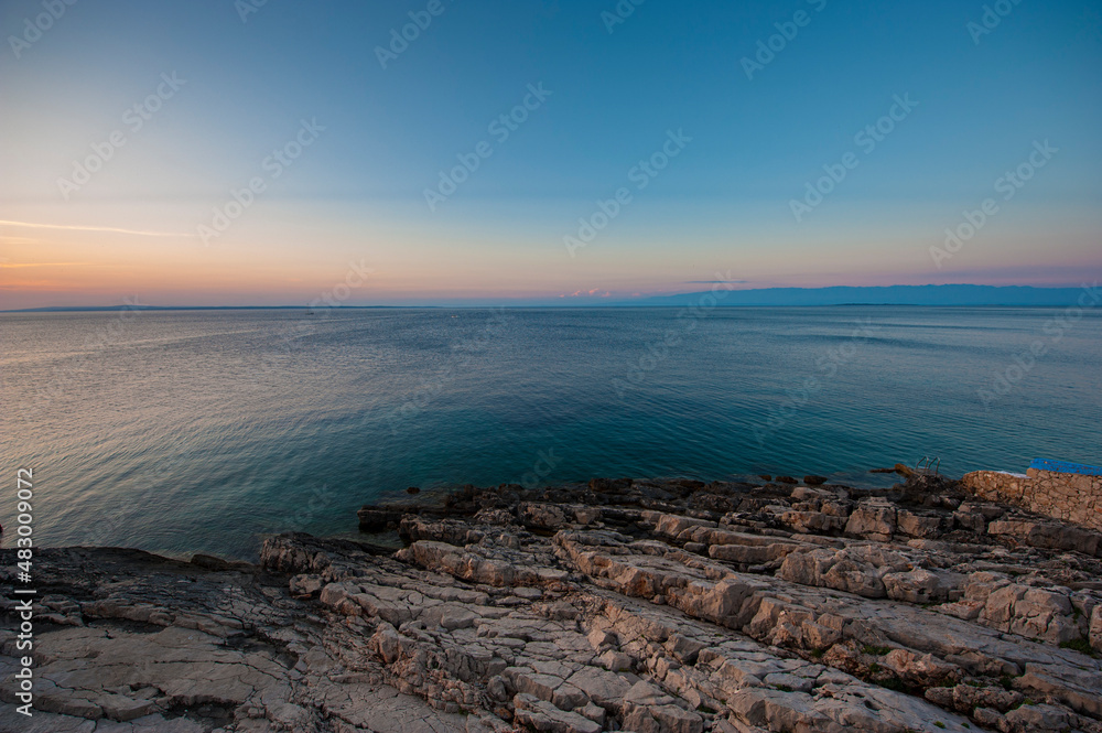Evening on a rocky beach overlooking the calm sea at Kamenjak, Croatia