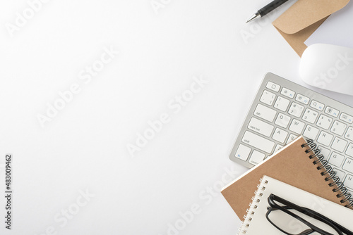 Top view photo of workstation keyboard computer mouse reminders glasses pen and envelope with paper sheet on isolated white background with empty space