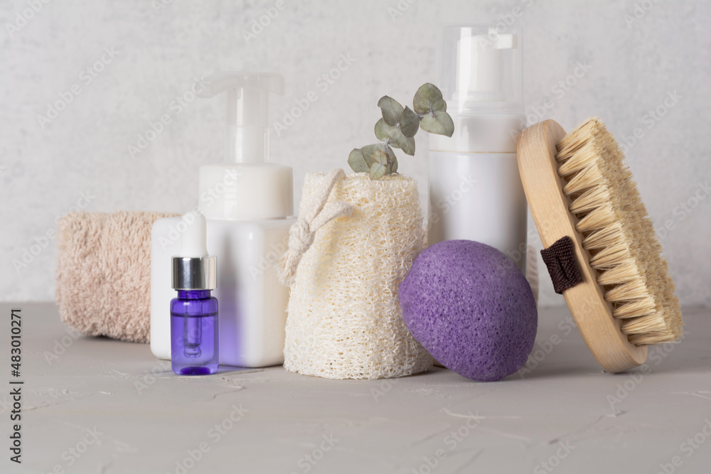 Spa cosmetic products and eco friendly bathroom accessories on gray texture background. Beauty, spa and wellness concept. Front view Spa cosmetic products and eco friendly bathroom accessories on gray texture background. Beauty, spa and wellness concept. Front view
