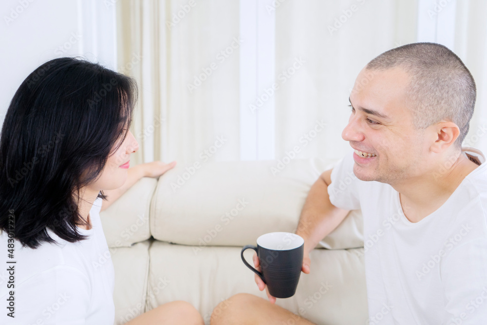 Romantic couple chatting together on the couch Romantic couple chatting together on the couch