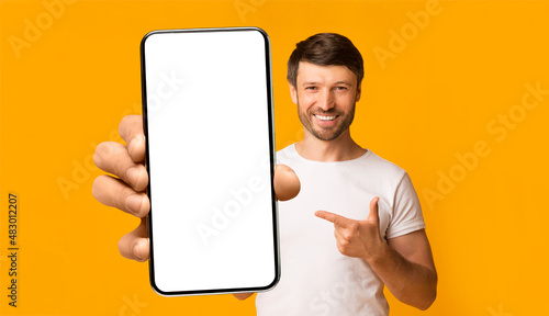 Fotografi Bearded guy showing white empty smartphone screen, closeup