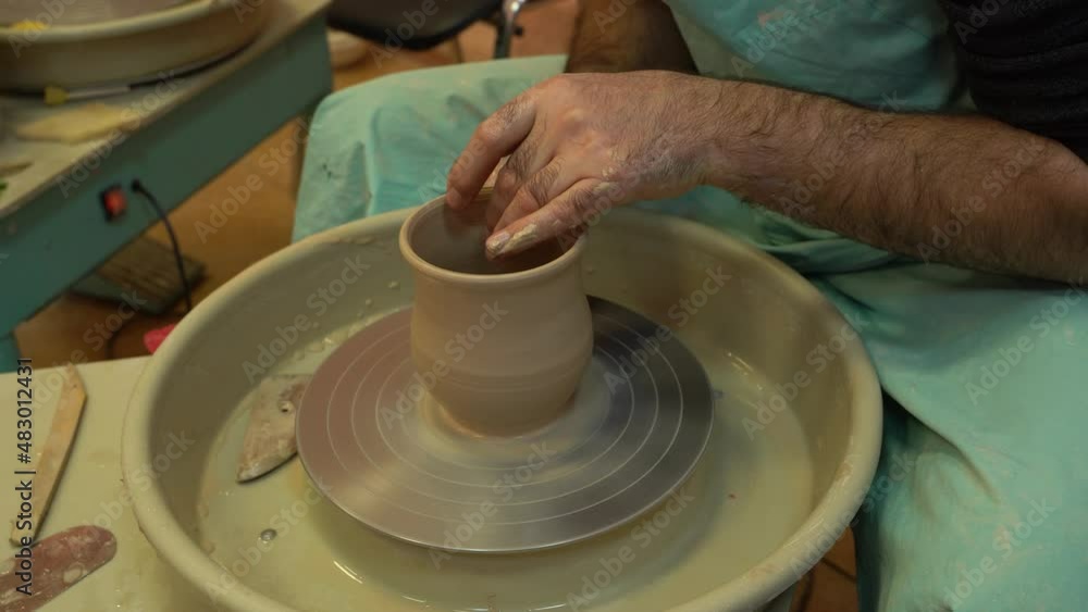The potter works on a pottery wheel. Clay bowls made of soft colored clay, working with clay. The potter works on a pottery wheel. Clay bowls made of soft colored clay, working with clay.