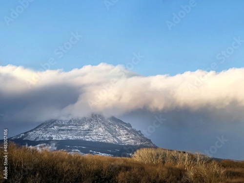 Natural background, landscape mountain top in clouds and blue clear sky