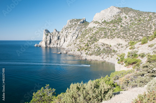 Karaul-Oba mountain massif and Blue bay with a motor boat moving to the so-called czar beach, Crimea