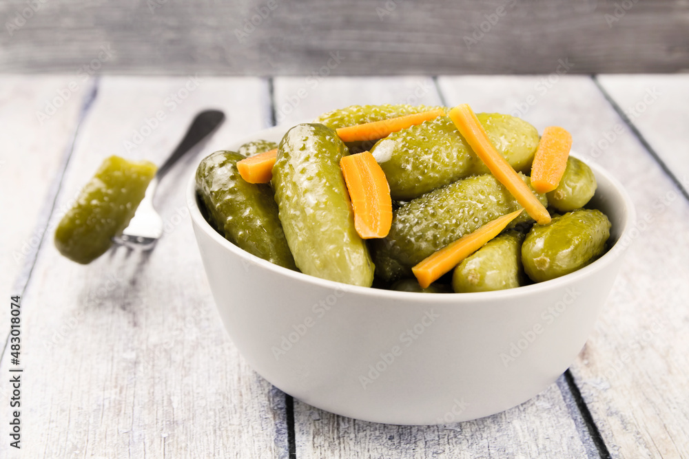 Pickled cucumbers in a bowl on a wooden rustic table Pickled cucumbers in a bowl on a wooden rustic table
