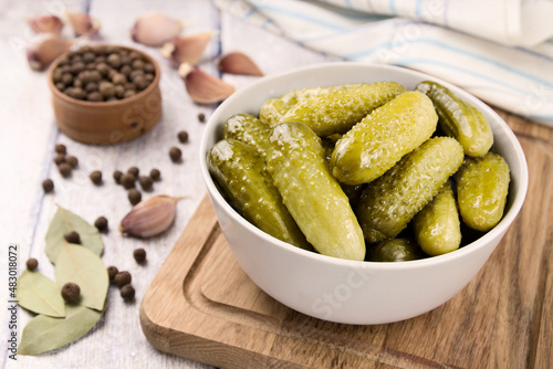Pickled cucumbers in a bowl on a wooden rustic table