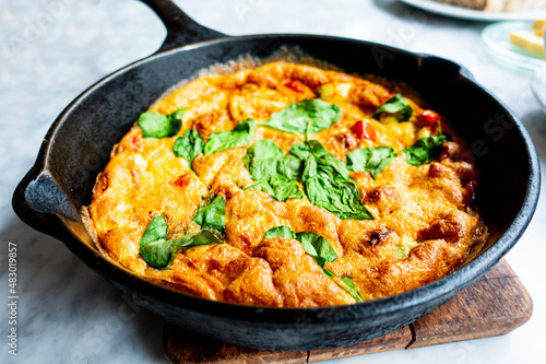 Delicious homemade omelet with vegetables cooked in oven and served in a traditional pan
