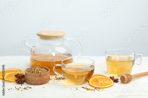 Concept of hot drink with buckwheat tea on white wooden table