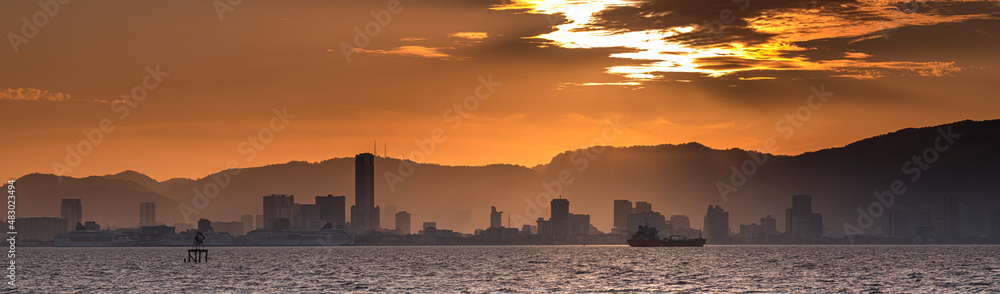 Scenery of a beautiful sunset with warm colors of the sun on a city skyline