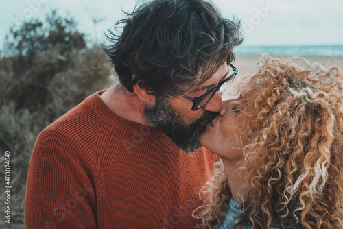 Canvastavla Adult people man and woman in love and relationship kissing at the beach with sea in background