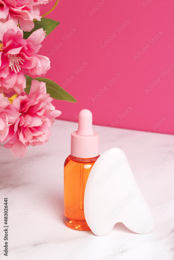 Glass dropper bottle on pink background. Skin care concept. Gua sha stone for face massage. SPA relax, face skin care and body treatment. Home skin care anti-aging tools, face serum bottle. Glass dropper bottle on pink background. Skin care concept. Gua sha stone for face massage. SPA relax, face skin care and body treatment. Home skin care anti-aging tools, face serum bottle.