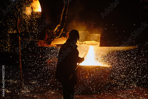 Metallurgist steelmaker takes a sample of liquid metal from a ladle. Ingot casting. Steel production. Metallurgy. Industry photo