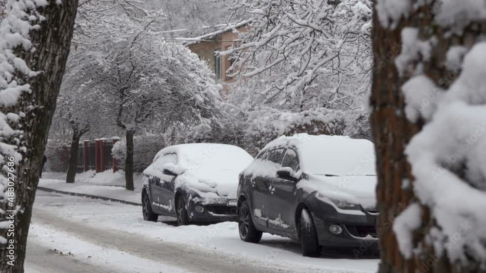 parked cars are covered with snow,two snow-covered cars parked on the street in winter parked cars are covered with snow,two snow-covered cars parked on the street in winter