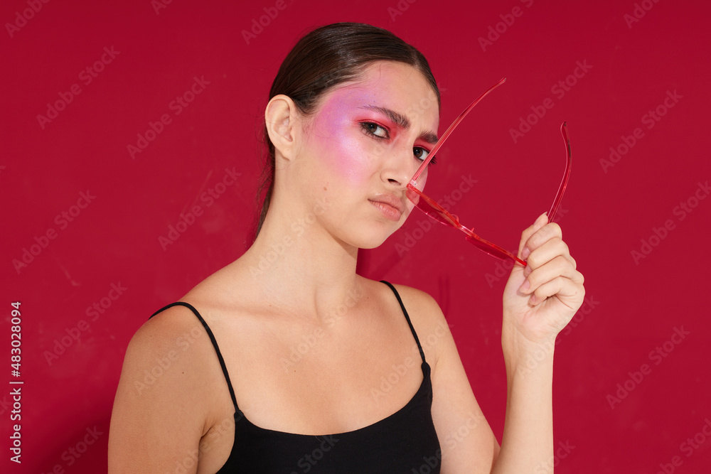 Sexy brunette woman in pink glasses makeup emotions cosmetics isolated background unaltered Sexy brunette woman in pink glasses makeup emotions cosmetics isolated background unaltered