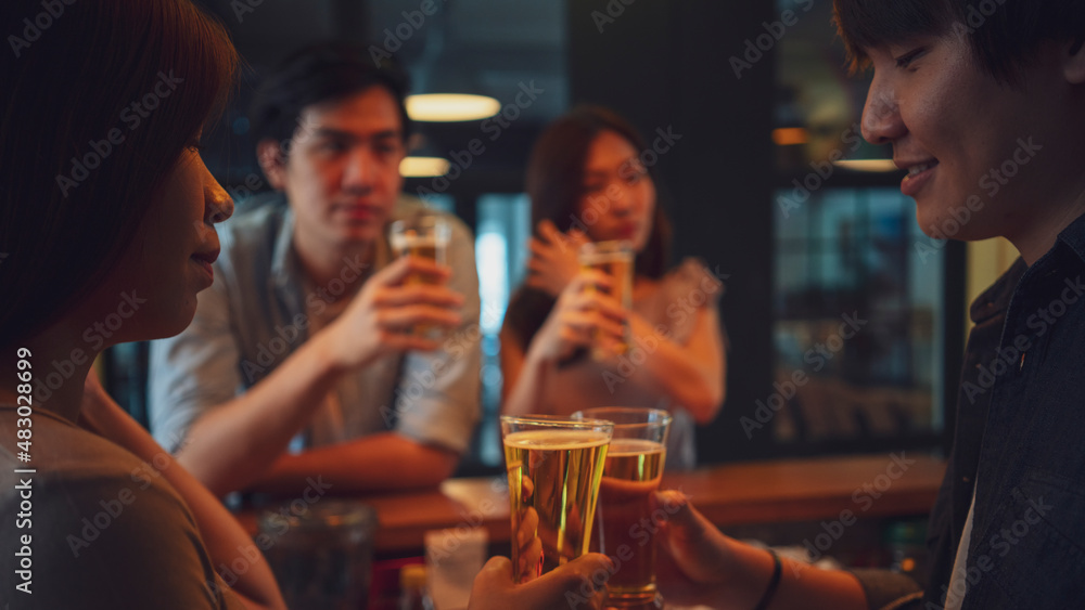 Group of Asian friend clinking a glass of beer and enjoy drinking beer at bar, alcohol, beer drinking, friend party, group of friend, casual meeting, bar and restaurant or friend and beer concept
