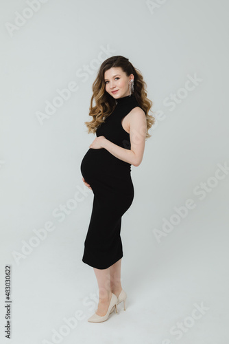 Pregnant woman touching belly in the studio