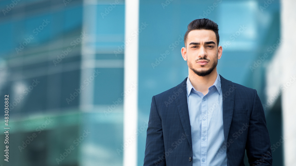 Handsome middle-eastern guy businessman posing next to office center Handsome middle-eastern guy businessman posing next to office center